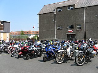 Many bikes parked in a field at a rally