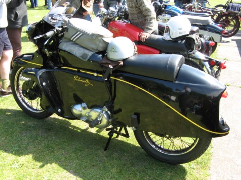 A great vintage motorcycle at an outdoor rally.