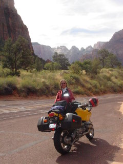 A motorcycle posing by a really big rock, somewhere in Utah