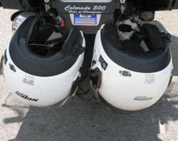Two helmets locked together on the back of a bike