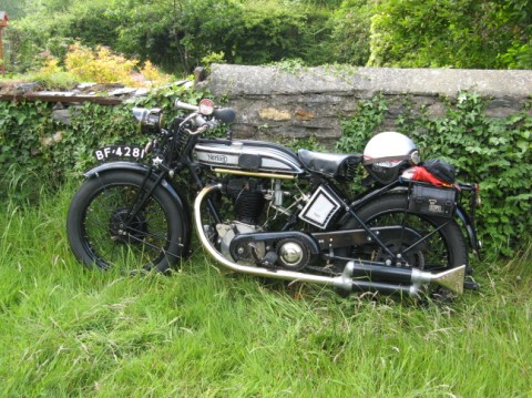 A beautiful vintage motorcycle, parked in a yard in the UK